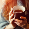 woman with red hair enjoying cup of tea